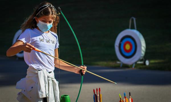 Girl gets ready to fire arrow